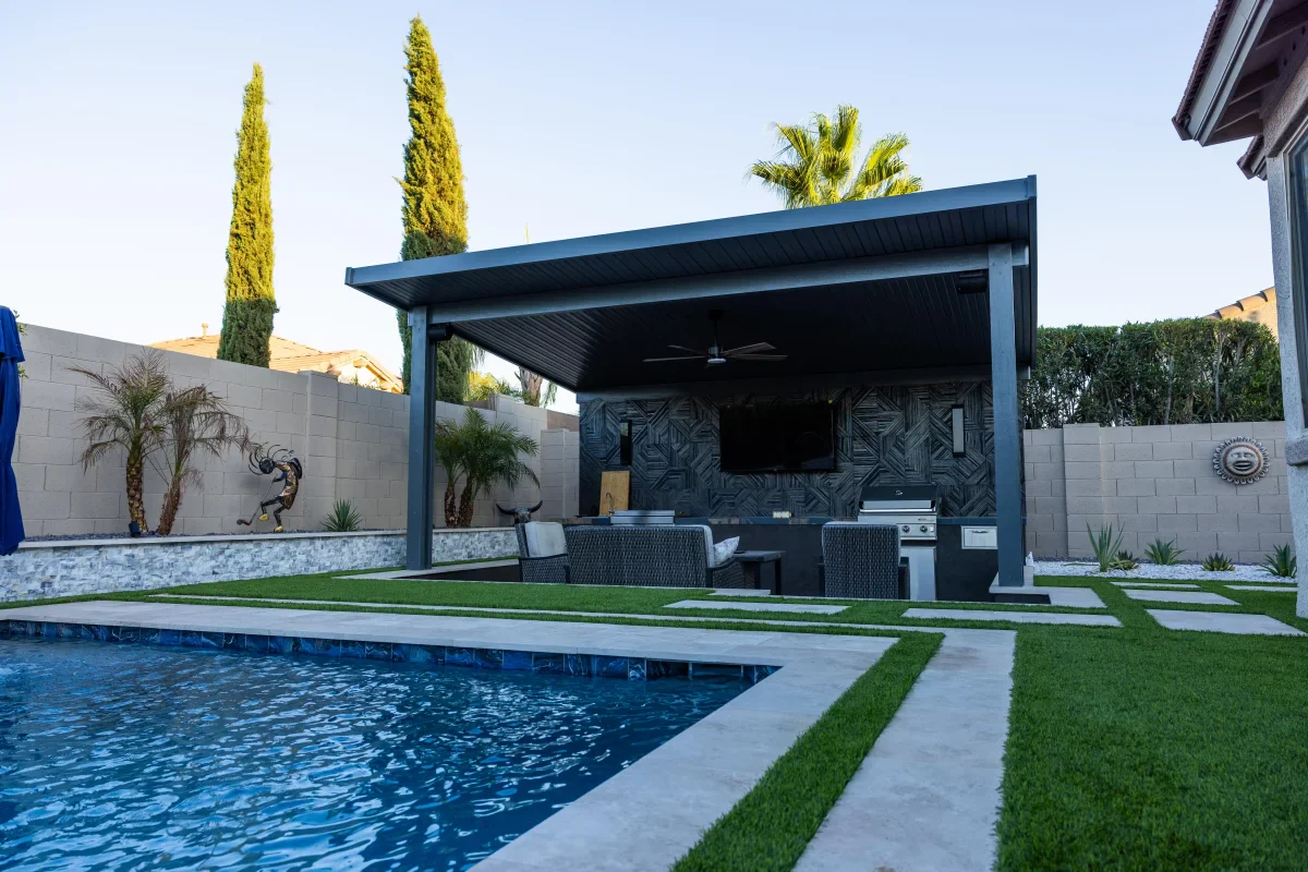 Completed Arizona backyard with a shaded outdoor kitchen and poolside living space